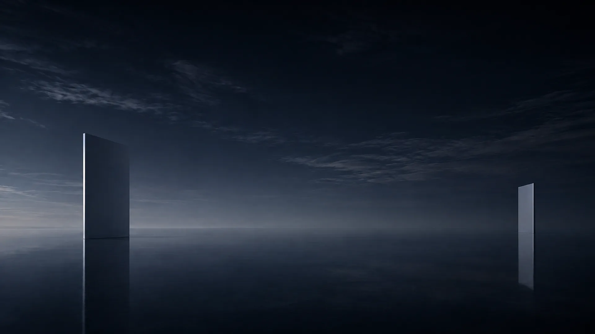 Two thin upright slabs stand far apart on a mirror still plane of water under a dark blue sky streaked with faint cloud, one tall at left, one small at right.