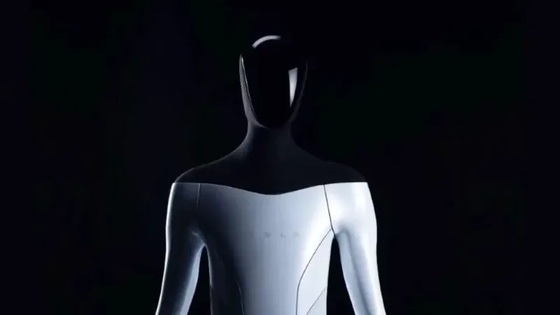 A white and silver humanoid robot photographed from the waist up against black, its head featureless and dark, with a faint wordmark barely visible across the smooth chest panel.